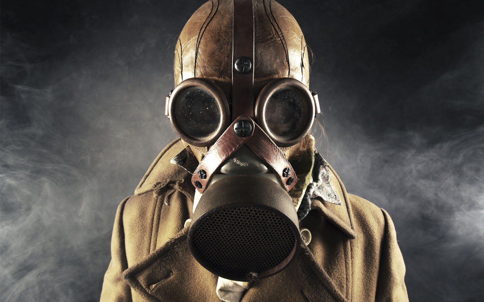 Mann im beigen Mantel in Ledermütze und Gasmaske Portrait 
